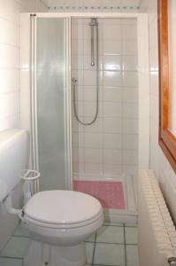 a white bathroom with a toilet and a shower at Villa delle Terme in Lignano Sabbiadoro