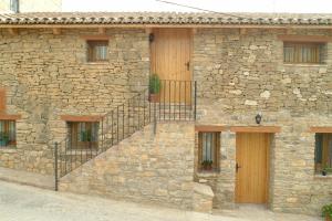 un edificio de piedra con una escalera en su lateral en Casa Contorna, en Agullo