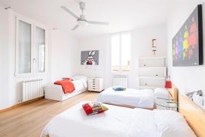 Habitación blanca con 2 camas y sofá en Skyline Central Apartment, en Bolonia