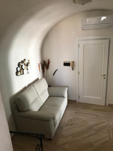 a living room with a couch and a door at Casa Cardi in Sperlonga