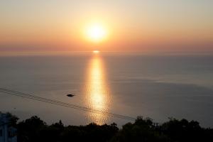 a sunset over the ocean with the sun in the sky at Alkmini in Agios Dimitrios