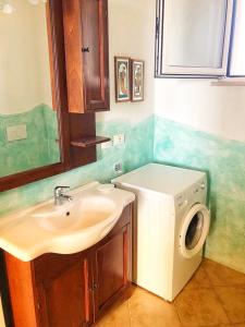 a bathroom with a sink and a washing machine at Villa Mariapaola in Torre Vado