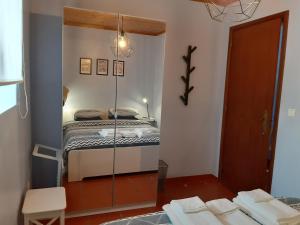 espejo en una habitación con cama en Alojamento Local de Santa Catarina, en Praia da Vitória