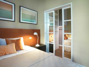 DRAGO d' ORO SUITES في فلورنسا: غرفة نوم بسرير ومصباح ومرآة