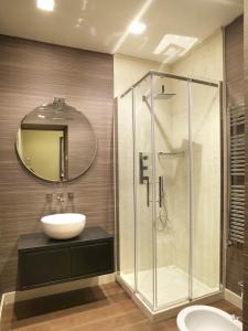 a bathroom with a sink and a glass shower at DRAGO d' ORO SUITES in Florence