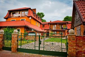 a house with an iron gate in front of it at Villa Akacja in Łeba