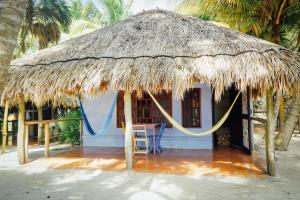 a small hut with a straw roof on the beach at Zamas Hotel in Tulum