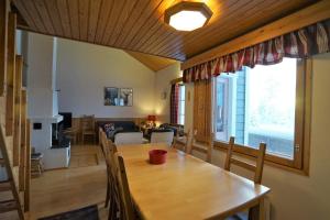 a dining room and living room with a table and chairs at Apartment Rentun Maja in Saariselka