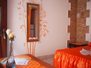a room with a bed and a mirror and a table at Xanadú B & B in Holguín