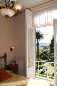 a bedroom with a bed and a large window at Villa La Argentina in Luarca