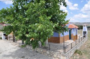 een gebouw achter een hek met een boom bij El Calar - Casas Rurales Luis in Moratalla