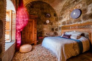 a bedroom with a bed in a stone wall at Hostal El Asturiano in Tarifa