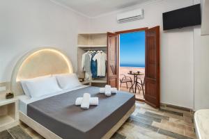 a bedroom with a bed with a view of the ocean at Nectarios Villa 2 in Fira