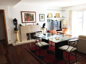 a living room with a table and chairs and a fireplace at Nobel Apartment in Park of Nations in Lisbon
