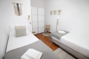 une chambre avec deux lits et une chaise dans l'établissement Apartamento nas Olaias a 5 minutos da Faculdade ISEL e IST, à Lisbonne