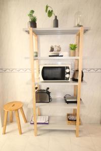 une étagère dans une cuisine équipée d'un four micro-ondes dans l'établissement Apartamento nas Olaias a 5 minutos da Faculdade ISEL e IST, à Lisbonne