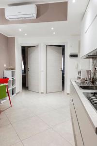 a large kitchen with white walls and white floors at MINERVA GUEST HOUSE in Pavia