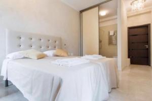 a white bedroom with a large bed with white sheets at Let's go to Rome in Rome