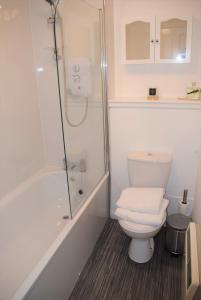uma casa de banho branca com um WC e um chuveiro em Kelpies Serviced Apartments Alexander- 2 Bedrooms em Falkirk