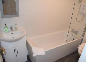 uma casa de banho com um lavatório, uma banheira e um WC. em Kelpies Serviced Apartments Alexander- 2 Bedrooms em Falkirk