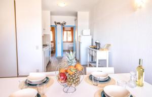 una cucina con tavolo e ciotola di frutta di Homey Experience - Sea Corner Apartment a La Maddalena