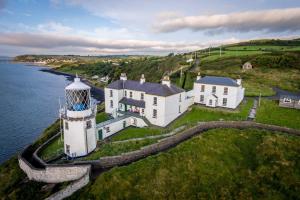an aerial view of a lighthouse on the water at The Barn at BallyCairn in Larne
