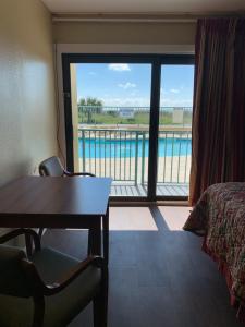 a room with a bed and a view of a pool at Sea Dunes Oceanfront in Myrtle Beach