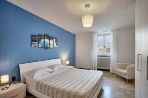 een slaapkamer met een bed en een blauwe muur bij COZY LAKE COMO APARTMENTS in Valmadrera