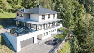 an aerial view of a white house with two cars parked at Bianca Apart in Mayrhofen