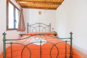 a bedroom with a bed with an orange comforter at Rifugio Gorropu in Dorgali