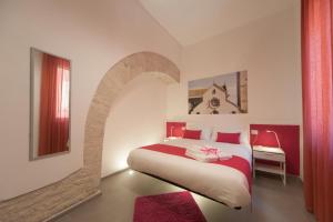 トラーニにあるLa Cattedrale dai Tettiのアーチ型の大型ベッドが備わるベッドルーム1室が備わります。