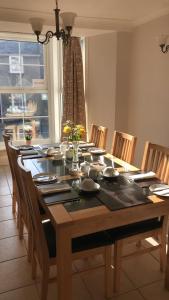 a dining room table with chairs and a large table with flowers at B&B Ty Cornel in Trefriw