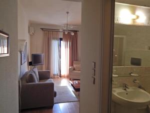 a bathroom with a sink and a living room at Philoxenia in Kavála