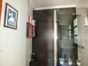 a shower with a glass door in a bathroom at La Chambre de Ker Briac in Funchal