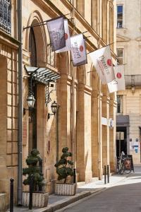 un edificio con dei cartelli appesi al lato di Best Western Premier HBEO Bordeaux Centre a Bordeaux