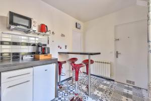 a kitchen with red stools on the floor at Promotion du jour - Le Cerisier - in Deuil-la-Barre +22 photos