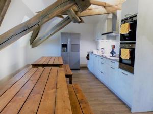 cocina con mesa de madera y nevera en La Maison Verneuil, en Paray-le-Monial