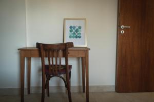 un escritorio de madera con una silla y una foto en él en Departamentos de Diseño Punto Norte - Pueyrredon en Salta