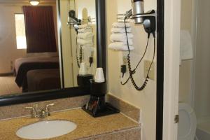 y baño con lavabo y espejo. en Americas Best Value Inn - Fredericksburg North en Fredericksburg