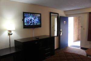 sala de estar con TV de pantalla plana en la pared en Americas Best Value Inn - Fredericksburg North en Fredericksburg