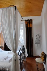 1 dormitorio con 1 cama con cortinas y mesa en Casa rural La sastreria de Adanero, en Adanero