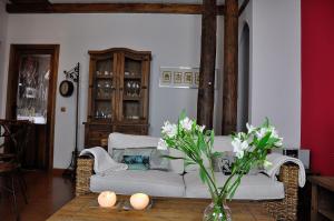a living room with a couch and a table with flowers at Casa rural La sastreria de Adanero in Adanero