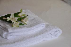 Una toalla blanca con flores en la cama en Casa rural La sastreria de Adanero, en Adanero