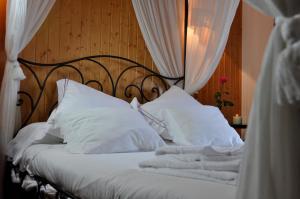a bed with white sheets and white pillows at Casa rural La sastreria de Adanero in Adanero