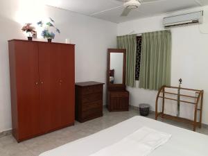 a bedroom with a bed and a cabinet and a mirror at Bentota Villa in Bentota
