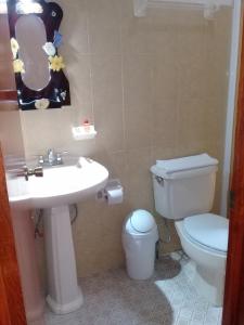 a bathroom with a white toilet and a sink at DON CELES in Paraíso