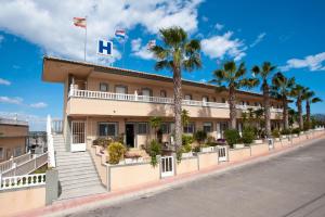 een hotel in een straat met palmbomen bij Hotel Costa Blanca Rojales in Rojales