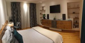 a bedroom with a bed and a flat screen tv at Ti Laouen Karaez in Carhaix-Plouguer