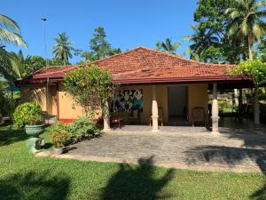 a small house with a patio in a yard at Bentota Villa in Bentota