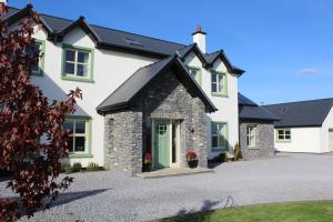 una gran casa blanca con una puerta verde en Luachra Lodge en Killarney